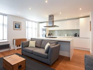 a living room with a couch and a kitchen at Pass the Keys Modern Seafront Apartment With Great Views Sleeps 4 in Portsmouth