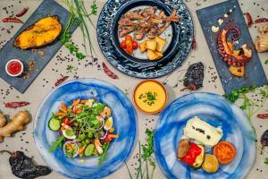 three blue plates of food on a table at Hotel Cabogata Jardín in Retamar