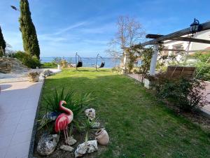 a garden with fake flamingos in the grass at SunVilla with hot tub in Koper +48 photos