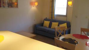 un salon avec un canapé bleu et une table dans l'établissement Promenade des Bains Apartment, à Saint-Raphaël