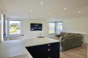 a kitchen and living room with a couch and a tv at Castle View Chalet by Clonlum Cottages in Newry