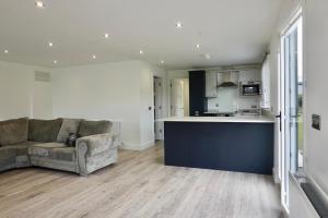 a living room with a couch and a kitchen at Castle View Chalet by Clonlum Cottages in Newry