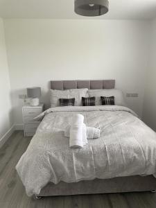 a white bedroom with a large bed with towels on it at Castle View Chalet by Clonlum Cottages in Newry