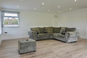 a living room with a couch and a ottoman at Castle View Chalet by Clonlum Cottages in Newry