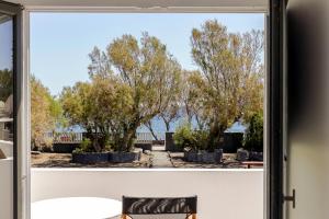 ein Fenster mit Blick auf die Bäume im Freien in der Unterkunft Exi Sea Side Suites in Perissa