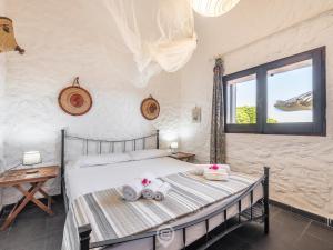 a bedroom with a bed with towels on it at House Eleonora - Villaggio Polifemo in Cala Sapone