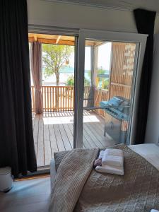 a bedroom with a bed and a balcony with a deck at Hollers Holiday Homes Haus Mary in Drage