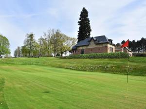 um campo de golfe com uma casa ao fundo em La conciergerie em Namur