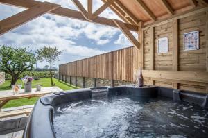 a large jacuzzi tub in a wooden house at Elidyr Cottage - 3 Bedroom Cottage - Amroth in Amroth