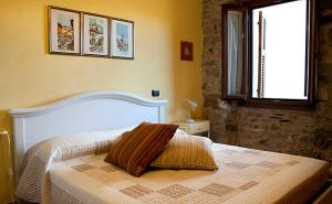 a bedroom with a large white bed with a window at Cà Fedora in Bagnone