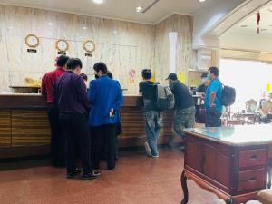 a group of people waiting at a counter in a restaurant at Abbo Hotel in Tainan
