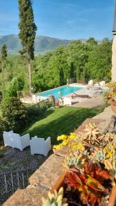 einen Garten mit Pool und einigen weißen Stühlen in der Unterkunft Tenuta di Vico Moricino in Anagni