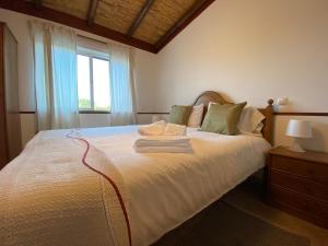 una camera da letto con un grande letto bianco e una finestra di Palma's Place Casanova Moradia #WIFI#POOL#RELAX a Faro