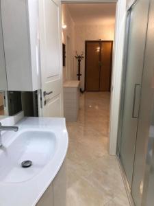 een witte badkamer met een wastafel en een douche bij Casa Vacanze Luigi&Maria in Pontremoli