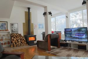 a living room with a tv and a wood stove at Vilas Ambasador Bratin Dol in Bitola