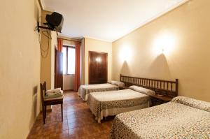 A bed or beds in a room at Pension Iberia