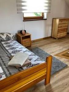 a bedroom with a bed and a wooden floor at Domek całoroczny Pod Lipą u GABI in Grywałd