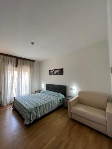 ein Schlafzimmer mit einem Bett und einem Sofa in der Unterkunft Hotel San Marco in Lido di Jesolo