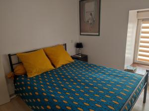 1 dormitorio con 1 cama con edredón azul y amarillo en Chambre tout confort, en Landujan