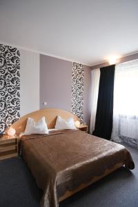 a bedroom with a large bed and a window at Hotel Rusca in Hunedoara