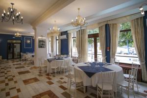 un comedor con mesas y sillas blancas en Hotel Rusca, en Hunedoara