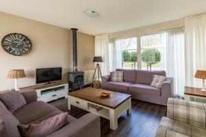 a living room with two couches and a tv at Antibes 232 - Kustpark Village Scaldia in Hoofdplaat