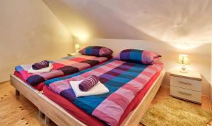 a bedroom with two twin beds with colorful pillows at Jacobs Resort House Kranjska Gora in Kranjska Gora