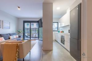 een keuken en een woonkamer met een bank bij Living4Malaga Pacific Terrace Apartment in Málaga