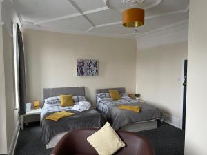 a bedroom with two beds and a couch in it at Dunes Hotel in Whitley Bay
