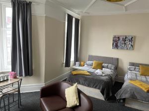 a bedroom with a bed and a chair and a couch at Dunes Hotel in Whitley Bay