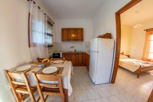 eine Küche mit einem Tisch und einem weißen Kühlschrank in der Unterkunft George Apartments in Arillas + 38 Fotos