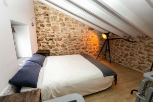 a bedroom with a bed and a stone wall at Casa Portelles in Denia