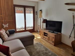 a living room with a couch and a flat screen tv at ES CÒVES in Vielha