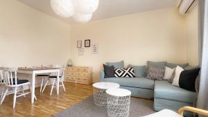 un salon avec un canapé bleu et une table dans l'établissement Lovely Apartment with Balcony in Pomorie Old Town by Flat Mаnаger, à Pomorie