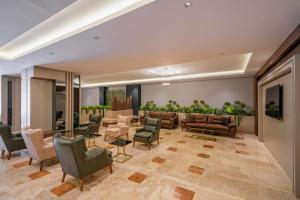 a waiting room with couches and chairs at New Safir Apart Hotel in Lara