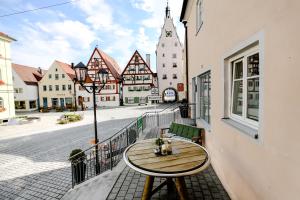 a wooden table on a balcony with a city street at Hotel Krone in Monheim
