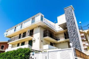 apartamentowiec z białymi balkonami i niebieskim niebem w obiekcie Diana Holiday Home w mieście Agrigento
