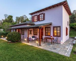 a white house with a patio and a yard at Gardenia Studios in Mouresi
