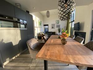 a dining room with a wooden table and chairs at GREEN VILLA in bester Lage - Dachterrasse mit Meerblick - großer eingezäunter Garten - kinderfreundlich - Hunde inklusive - 4 Sterne Resort - direkt am Strand - Pool inklusive in Hulshorst +93 photos