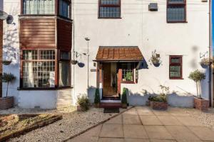 a white house with a brown roof at Camaraderie Guest House in York