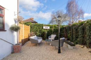 eine Terrasse mit Möbeln und ein Schild, auf dem neue in der Unterkunft Camaraderie Guest House in York