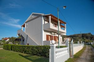 a white house with a white fence at George Apartments in Arillas