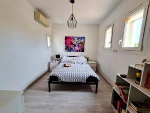sypialnia z łóżkiem i obrazem na ścianie w obiekcie Villa élégante à Ollioules + Piscine w mieście Ollioules