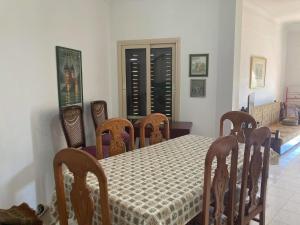 a dining room with a table and chairs and a table and a table and chairs at Location Maison en bord de mer, Nord Egypte in Al Ḩammām