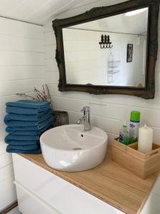 a bathroom with a sink and a mirror and towels at Secret Garden Glamping in Lymington