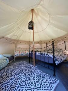 a bedroom with two beds in a tent at Secret Garden Glamping in Lymington