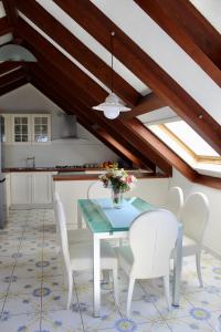 a dining room with a table and white chairs at Guest House Malù in Scala