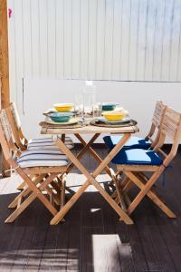 un tavolo in legno con due sedie, piatti e bicchieri di Vila Saudade a Costa da Caparica