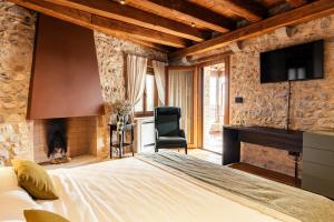 1 dormitorio con 1 cama, TV y silla en Casa del Vicario en Fagagna
