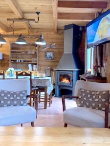 a living room with a fireplace and a table and a television at Chalet de 3 chambres avec piscine partagee sauna et terrasse a Le Devoluy in Le Dévoluy